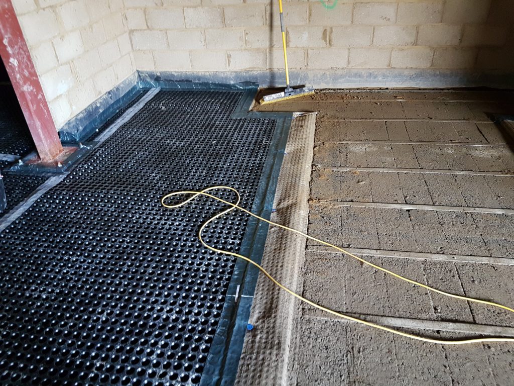 Wall membrane and floor membrane meeting at a change in flooring levels