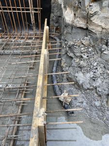 Permanent perimeter drainage around the basement being installed