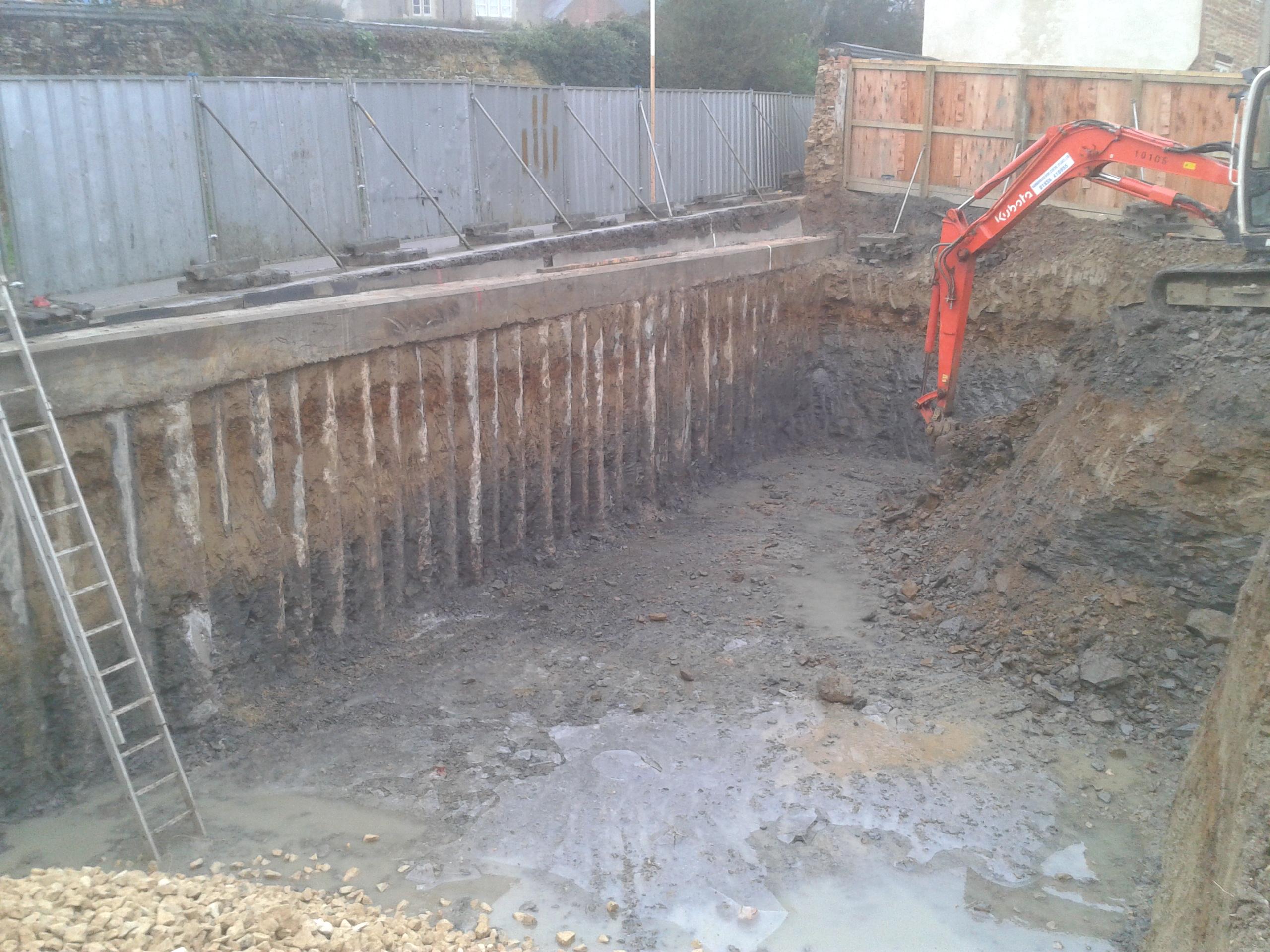 Contiguous piles under a linking ring beam securing the road next to the house